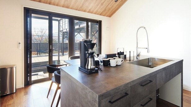 Una cocina moderna con una isla grande, una cafetera y un fregadero.