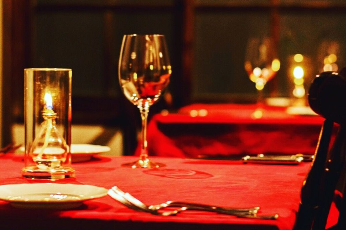 A table set for dining with a candle, a wine glass, and a plate.