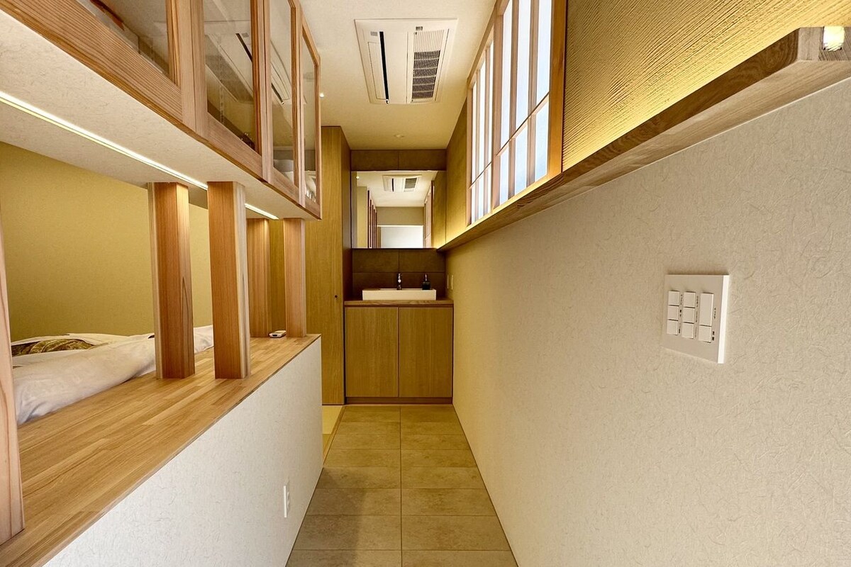 A narrow hallway with wooden beams and a bed on the left.