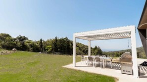 A covered outdoor seating area with a grill and chairs. - Doggywood Awaji Island (Awaji)