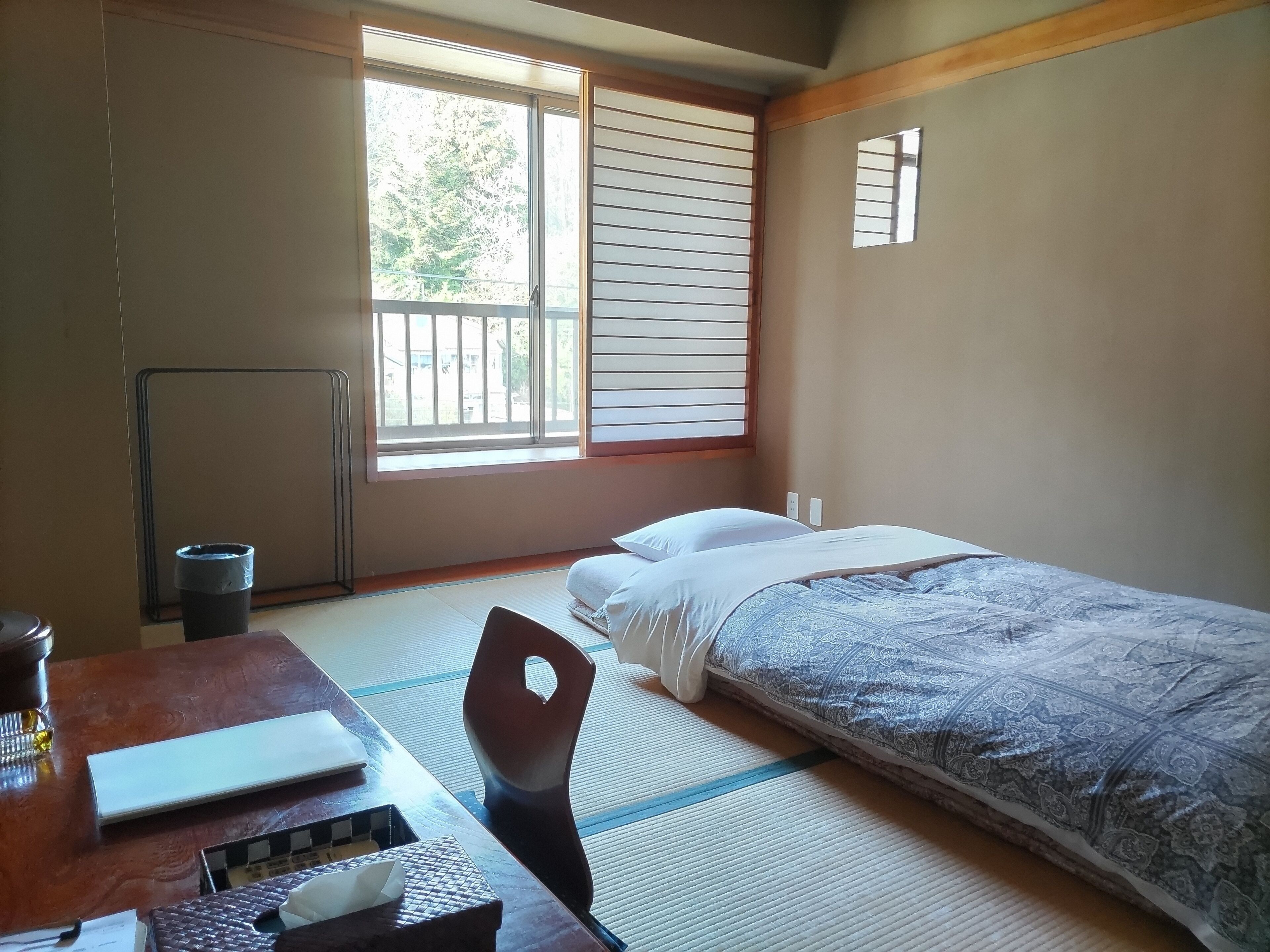 Een kamer met een bed, een bureau en een radiator.