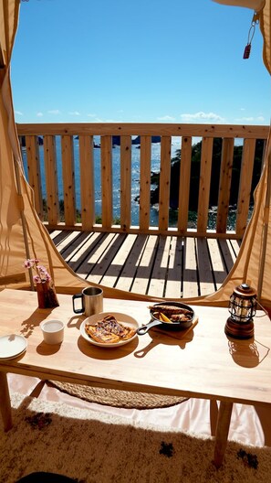 A wooden deck with a table set for a meal, overlooking a body of water. - Otsuki Outdoor Field Kashinishi (Otsuki)