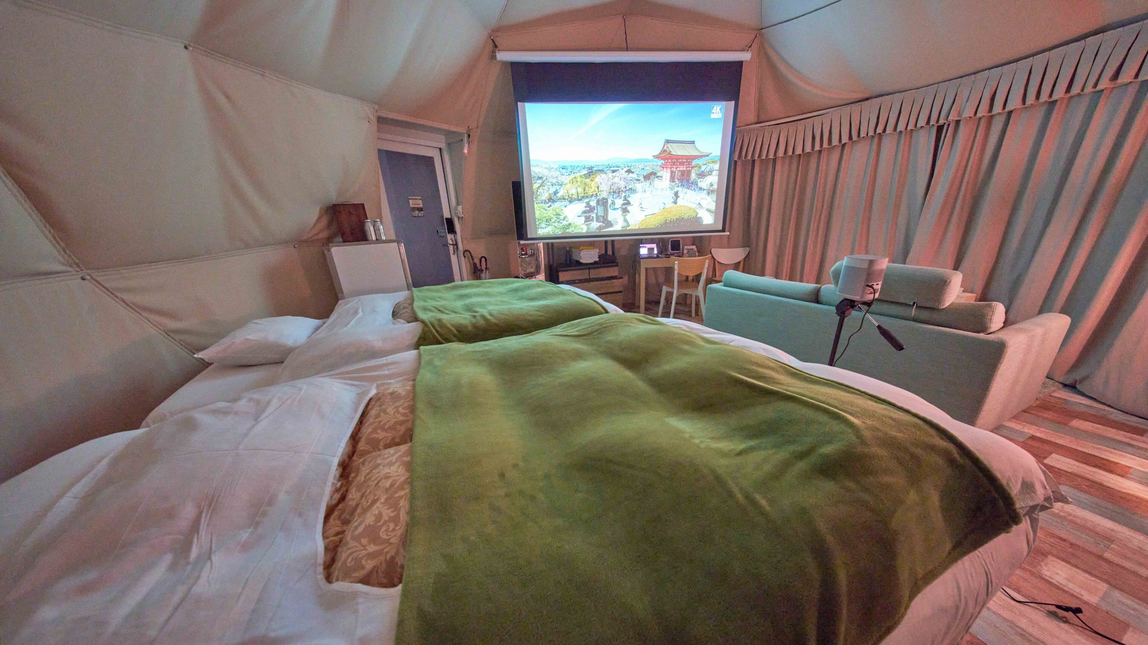 Een hotelkamer met twee bedden, een televisie, een bank en een bureau.