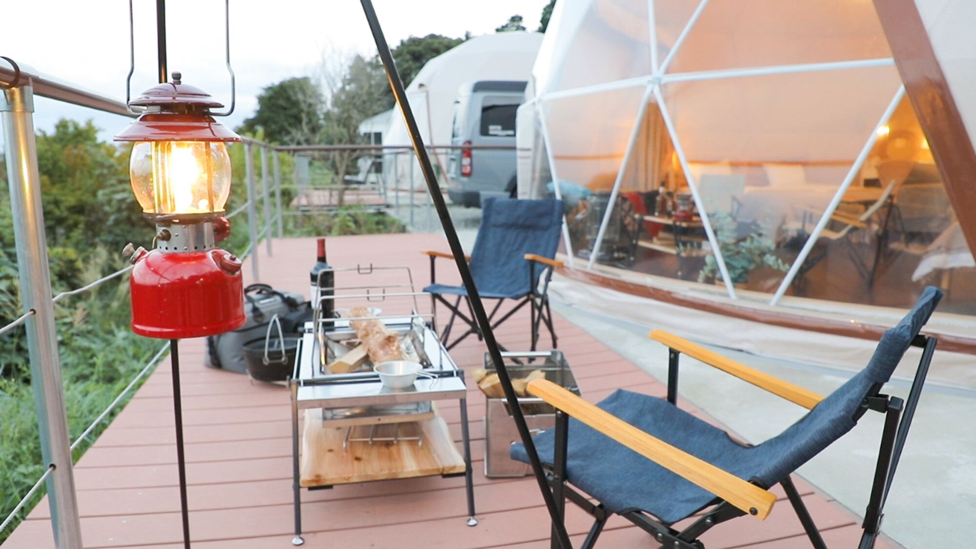 A cozy outdoor seating area with a table set for a meal, a chair, and a hanging lantern.