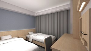 Ein Hotelzimmer mit zwei Betten, einem Schreibtisch und einem großen Fenster mit Vorhängen.