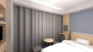 Ein modernes Hotelzimmer mit einem großen Bett, einem kleinen Schreibtisch, einem Fernseher und einem Kleiderschrank.