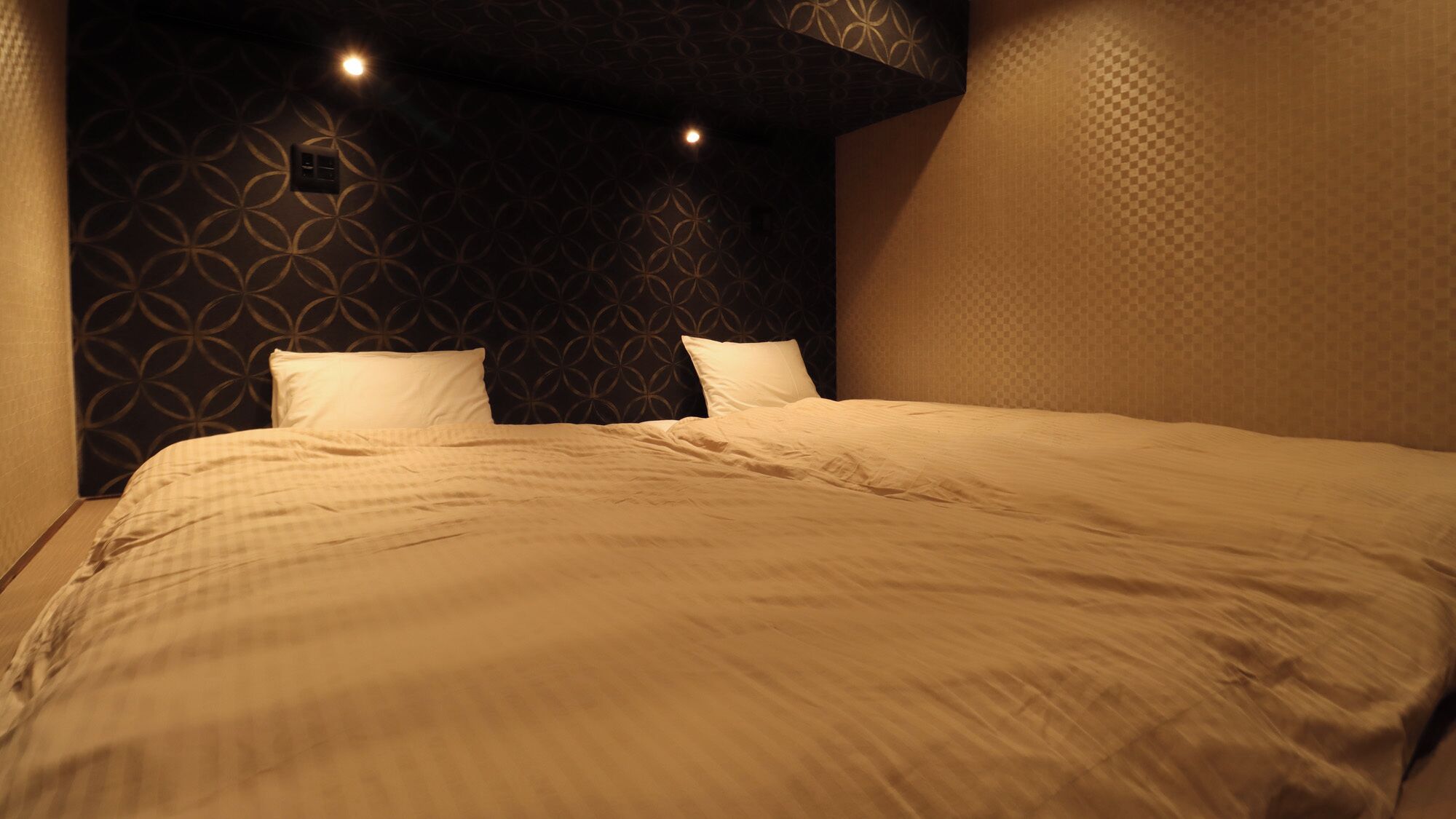 A neatly made bed with a patterned headboard and two pillows.