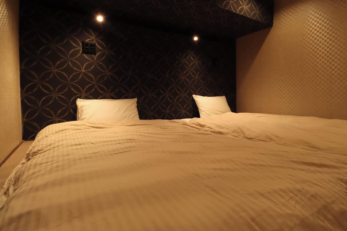 A neatly made bed with a patterned headboard and two pillows.