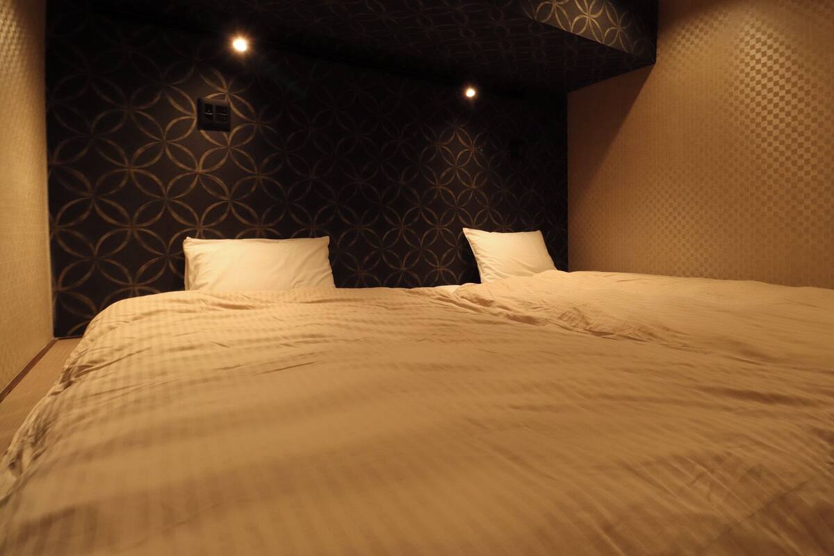 A neatly made bed with a patterned headboard and two pillows.