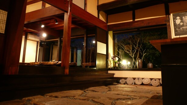 A traditional Japanese building with wooden beams and tatami mat flooring. - Hananoki Inn (Sado)