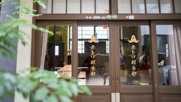 A traditional Japanese building with sliding doors and a sign with Japanese characters.