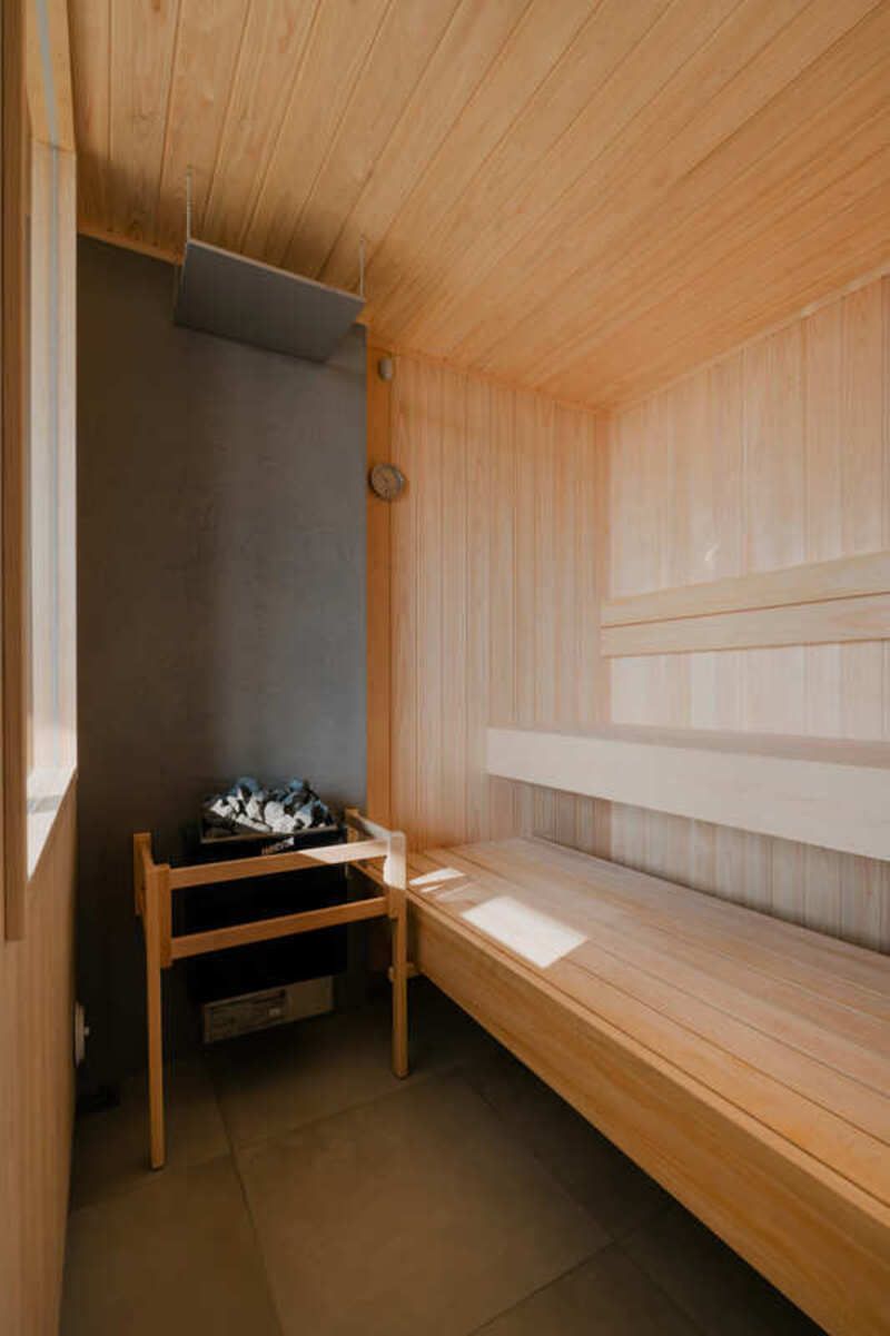 A sauna room with wooden benches, a bench with a towel, and a small table with a towel.
