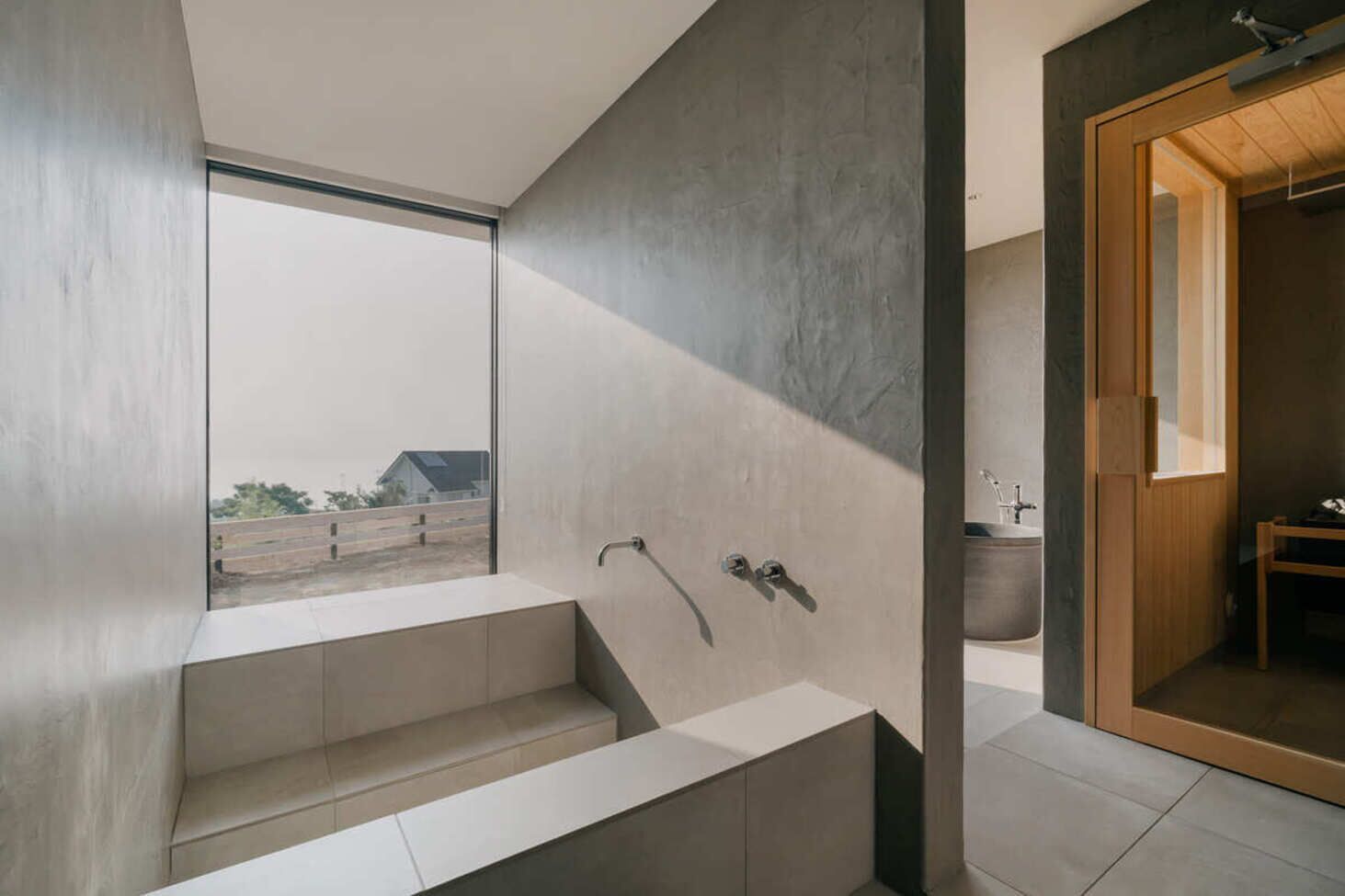 Une salle de bain moderne dotée d’une grande baignoire, d’un espace douche et offrant une vue sur l’extérieur.