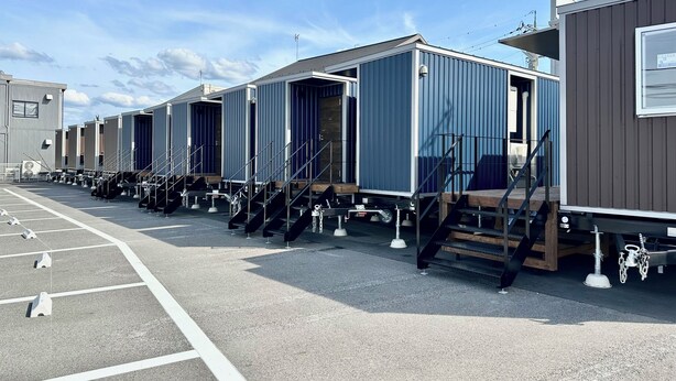 A row of modular cabins with external stairs and a parking lot. - PB Stay Konan (Koka)