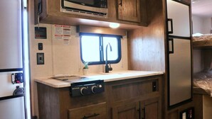 A compact kitchenette with a microwave, stove, and sink. - Costa Blu Awaji Island West Coast (Awaji)