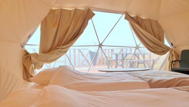 A cozy tent with a bed, a table, and a chair. - Costa Blu Awaji Island West Coast (Awaji)
