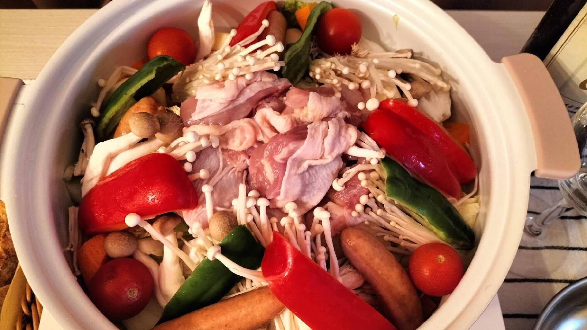 A bowl containing various raw ingredients including meat, mushrooms, and vegetables.