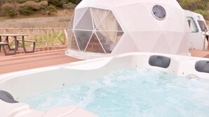 A hot tub with a transparent dome structure, a picnic table, and a wooden deck. - Costa Blu Awaji Island West Coast (Awaji)