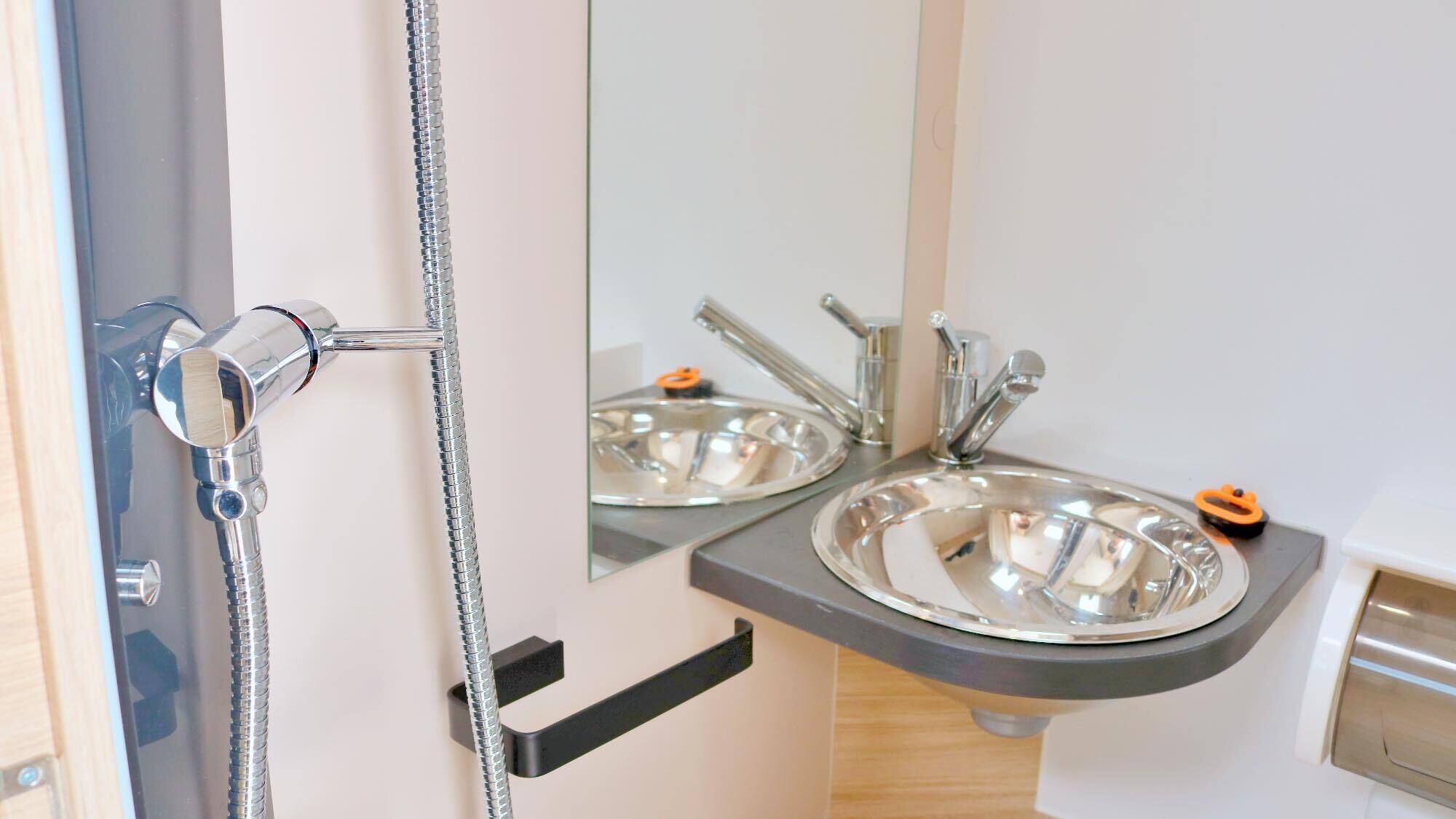 A bathroom with a shower, two sinks, and a mirror.
