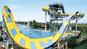 Un parque acuático grande con un tobogán de agua destacado y una zona de piscina.