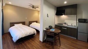 A hotel room with two beds, a small dining table, a microwave, and a refrigerator. - Chi Chi Nu Ji (Kunigami)