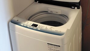 Un lave-linge Haier à chargement frontal, doté d’un panneau de commande, d’une porte et d’une étiquette indiquant les instructions.