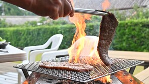 A steak being grilled over an open flame on a portable grill. - Villa Revolla (Makinohara)