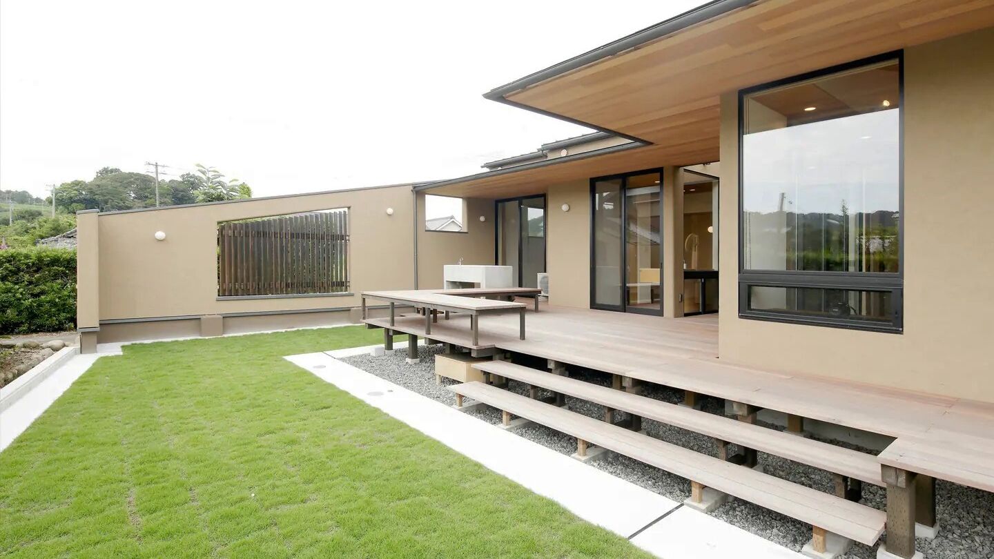 A modern house with a patio, a dining area, and a large window.