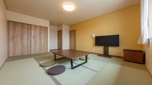 A room with tatami flooring, a low table, a television, and a wardrobe. - Ryokan-isamiya (Soma)