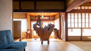 Un interior japonés tradicional con suelo de tatami, una escultura de madera y puertas correderas.