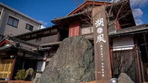 Un edificio japonés tradicional con un letrero de madera que muestra caracteres japoneses.
