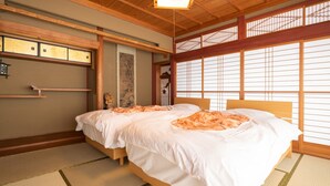 Una habitación tradicional japonesa con suelo de tatami, una cama de madera con ropa de cama blanca y puertas correderas shoji.