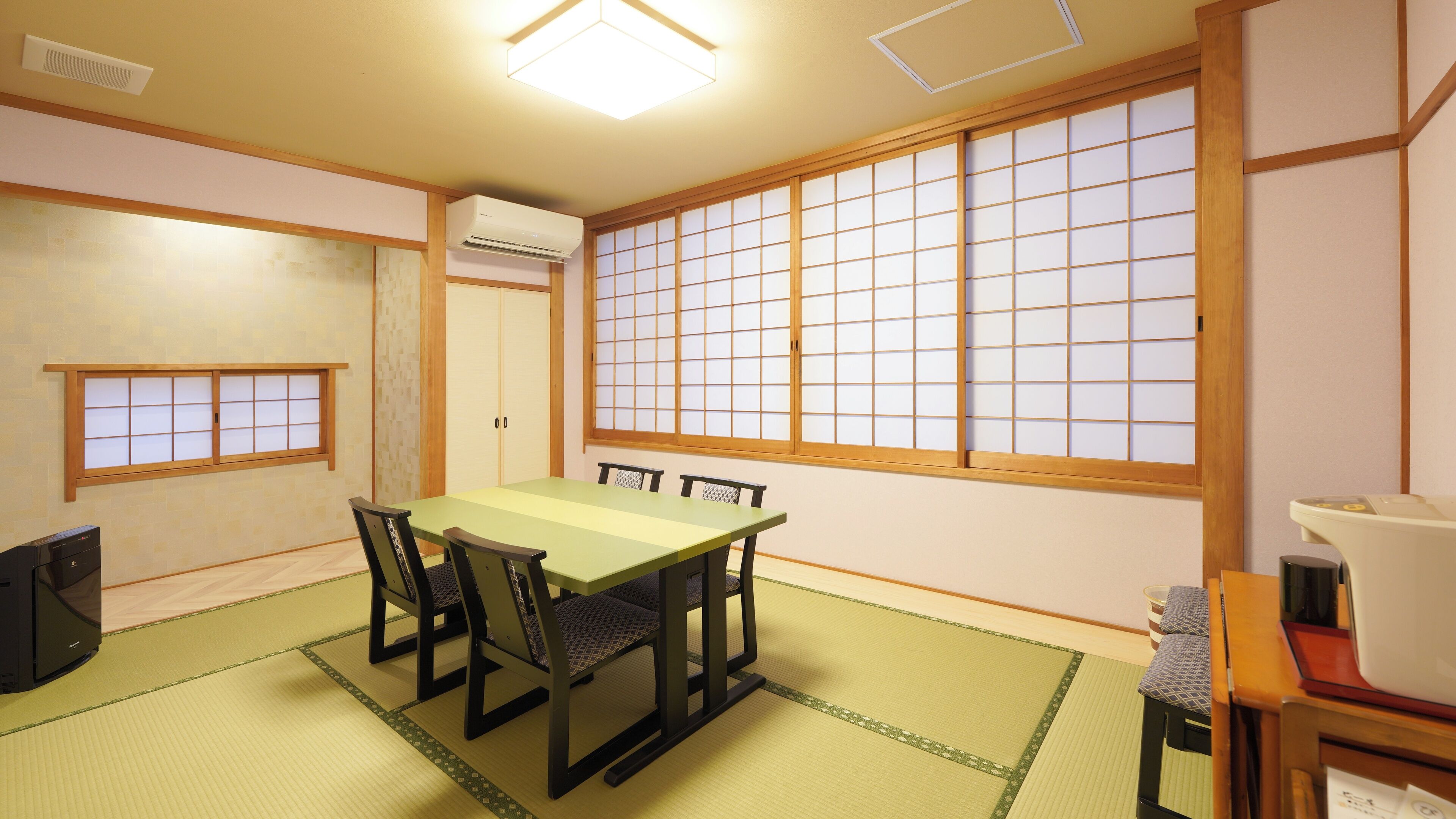A traditional Japanese-style room with tatami flooring, a low table, and shoji screens.