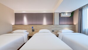 A hotel room with two single beds, a wooden headboard, a bedside table with a phone, and an air conditioning unit. - Winsome Hotel Guangzhou Tianhe Huajing Road Metro Branch (Guangzhou)