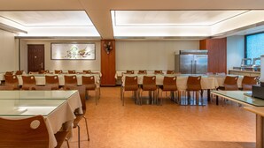 A conference room with glass tables and wooden chairs, a large painting on the wall, and a refrigerator in the corner. - Winsome Hotel Guangzhou Tianhe Huajing Road Metro Branch (Guangzhou)