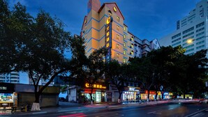 A multi-story hotel with a distinctive zigzag facade, located on a city street with trees and other buildings around. - Winsome Hotel Guangzhou Tianhe Huajing Road Metro Branch (Guangzhou)