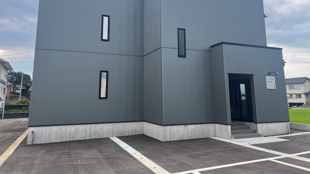 Un edificio moderno con techo plano, dos ventanas visibles y un letrero que indica la habitación número 8.