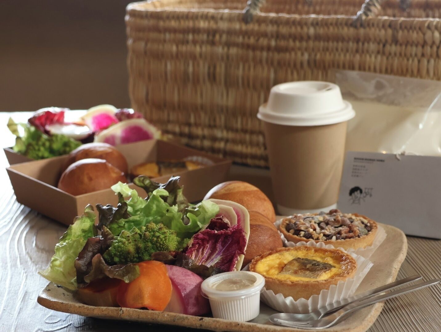 A tray with various food items, a coffee cup, and a basket in the background.