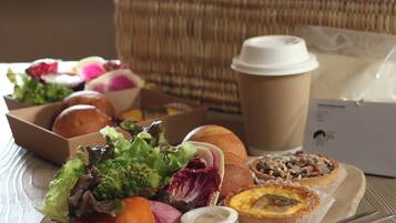 A tray with various food items, a coffee cup, and a basket in the background.
