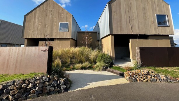 A modern two-story building with a concrete facade and a small window on the upper floor. - Cottage Nil/noi (Masuda)