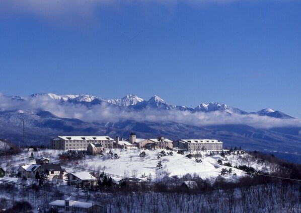 Un pueblo cubierto de nieve con edificios y una montaña al fondo.