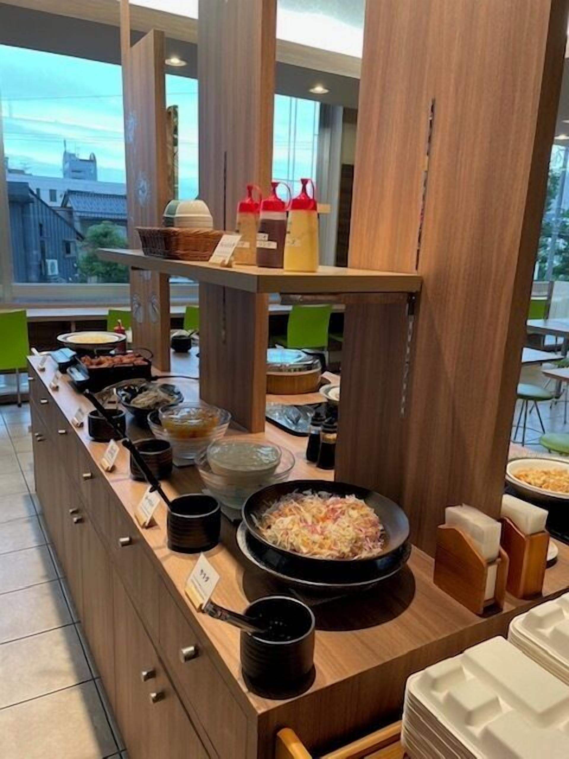 A buffet setup with various food items and condiments.