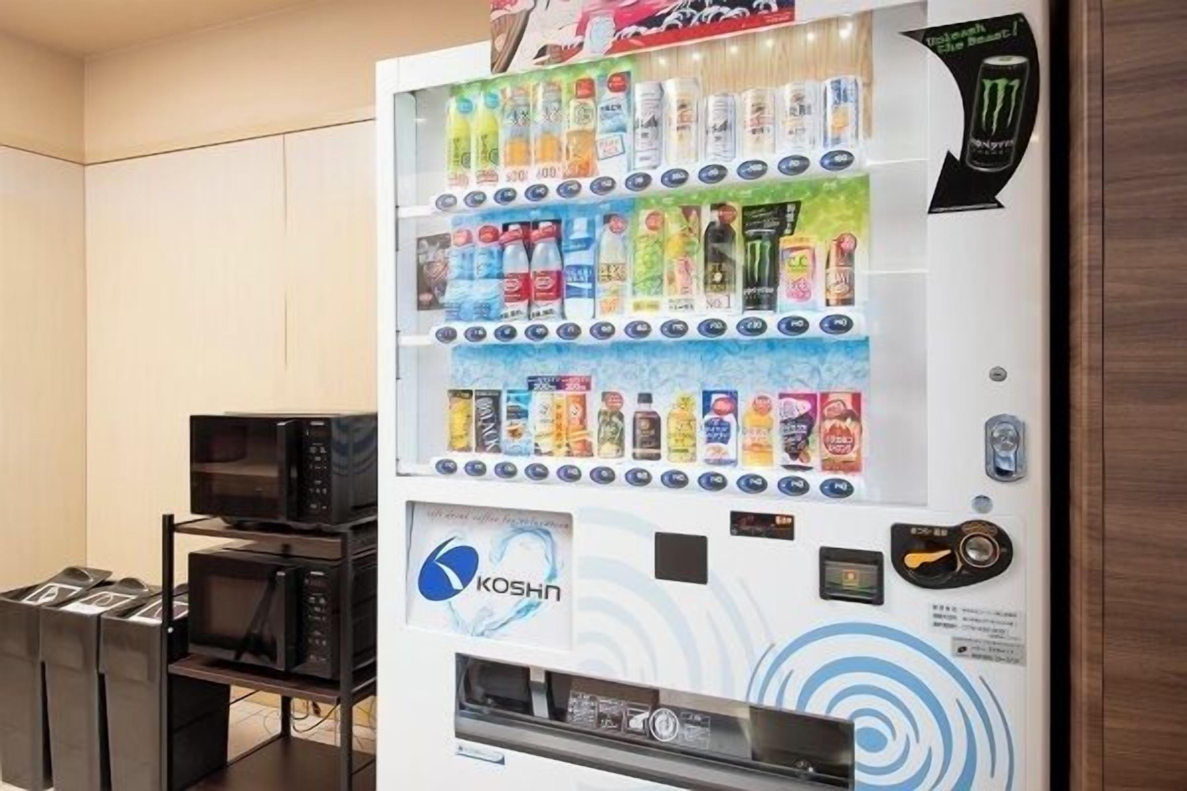 A vending machine with various beverages and snacks, a microwave, and a Kosha logo.