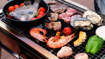 Diverse zeevruchten en vlees worden op een barbecue gegrild.