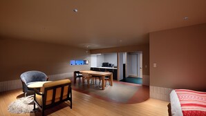 Une pièce spacieuse avec un plancher en bois, une table à manger, un canapé et un lit.