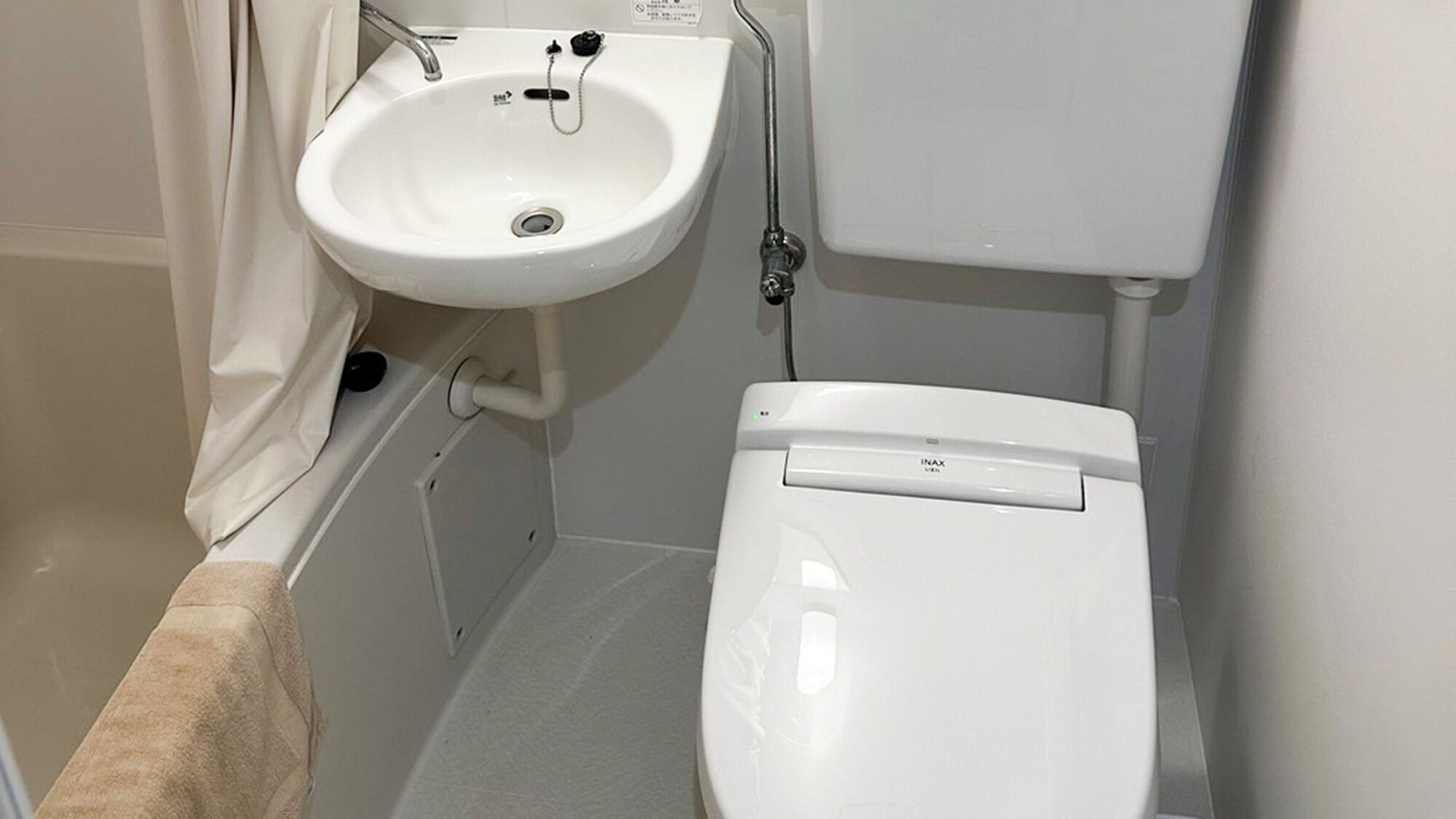 A bathroom with a white sink, a toilet, and a shower area.
