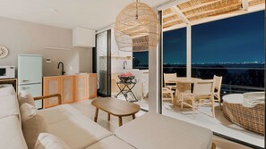 A modern living room with a sofa, a small table, and a grill area. - Okutass Resort Villa Bali (Awaji)