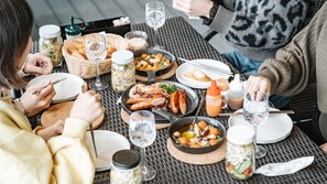 A dining table with various dishes, including seafood and salads, and multiple glasses of water. - Hario Beach Walk (Sasebo)
