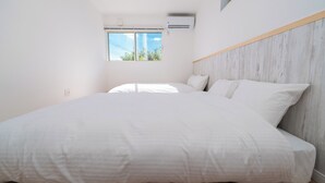 Une chambre dotée d’un grand lit, d’une fenêtre offrant une belle vue et d’un appareil de climatisation.