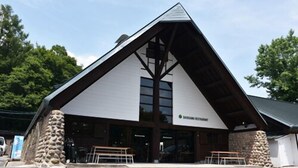 A building with a triangular roof and stone pillars. - Hiruzen Shiogama Camping Village (Maniwa)